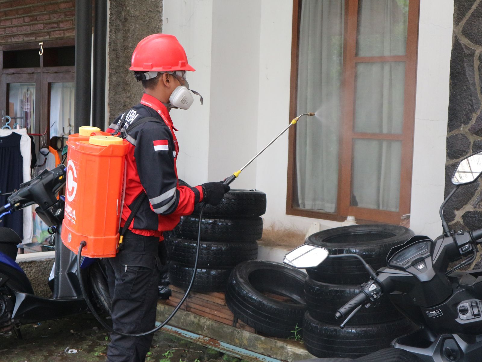 A licensed BuzzGuard technician treating a property perimeter