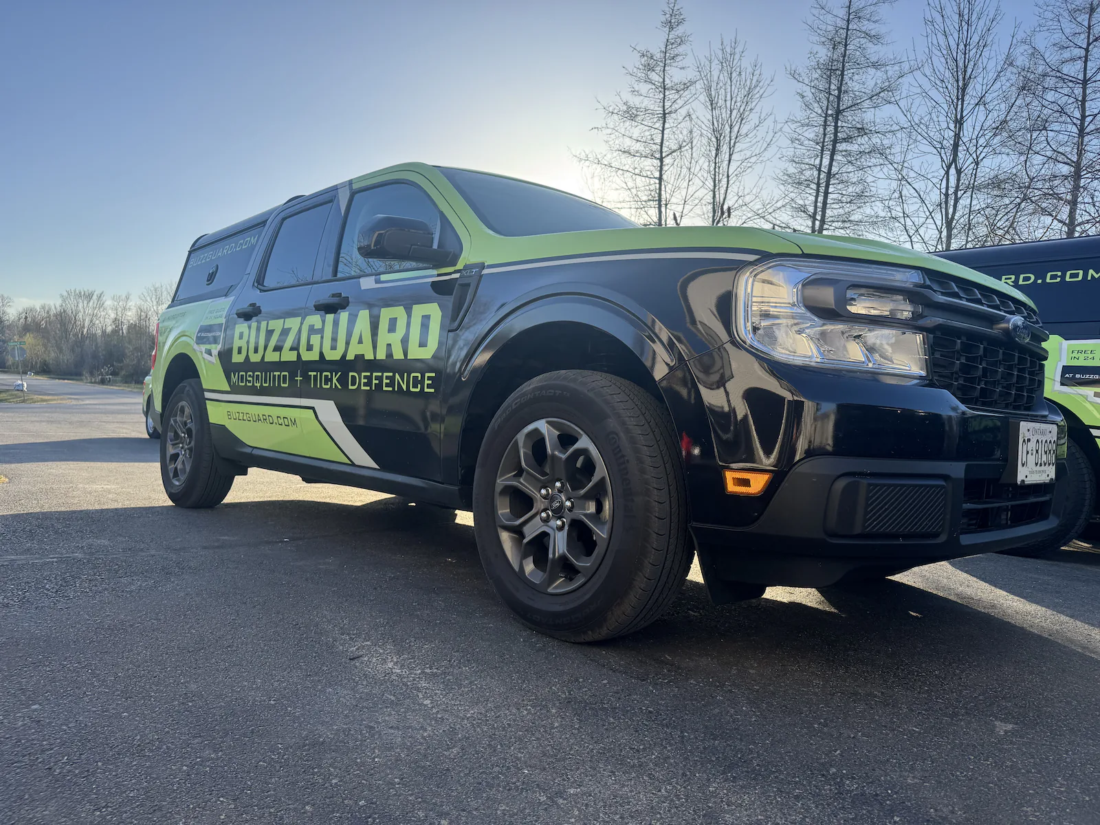 The wrapped BuzzGuard service truck parked on site